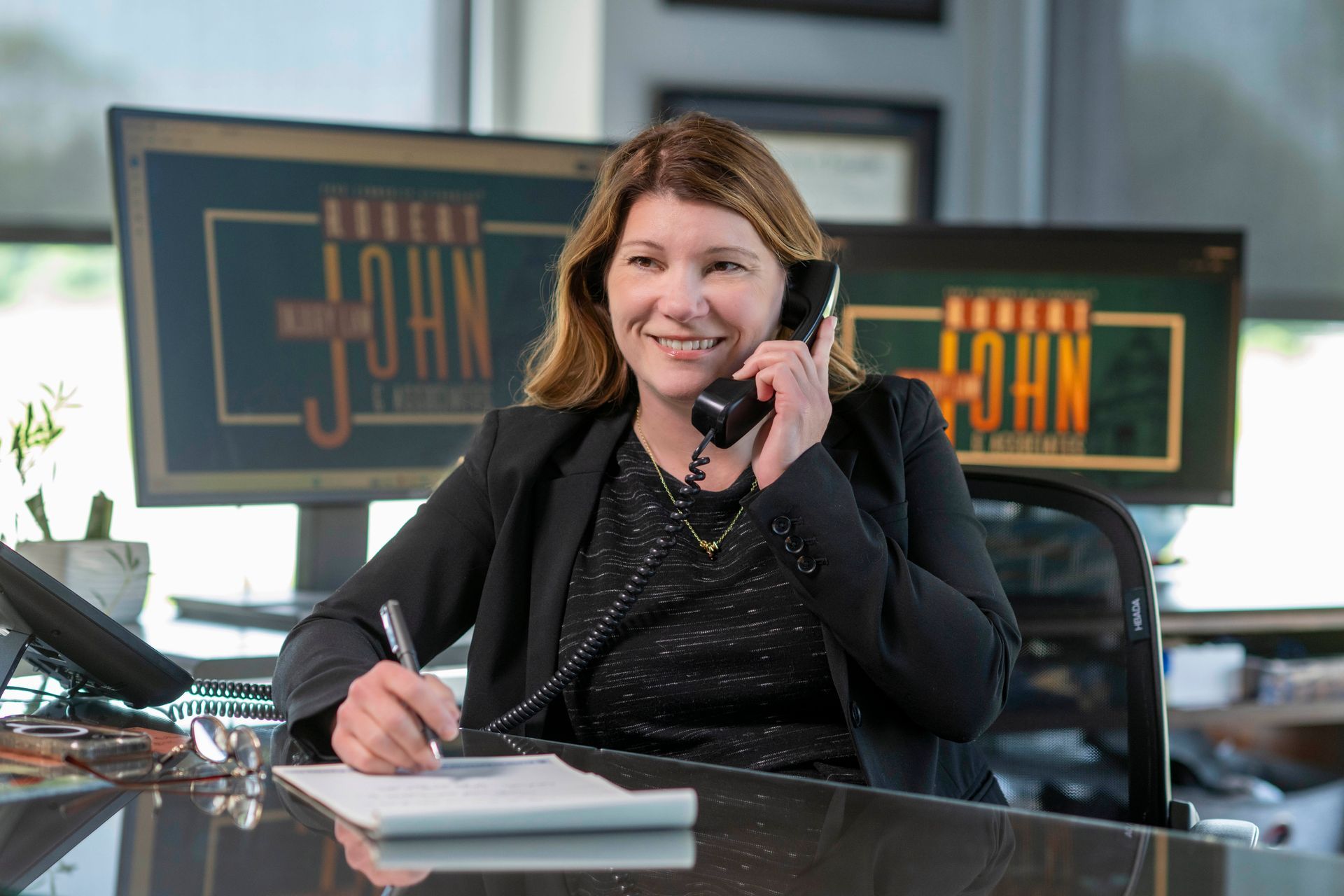 Sacha Armstrong smiling while speaking with someone by phone.