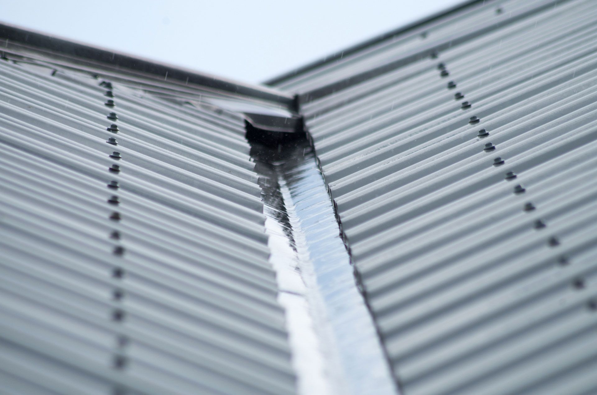 Close-up of a Metal Roof's Corner, Showing the Converging Panels and a Gutter — Your Craftsmen in Wallsend, NSW