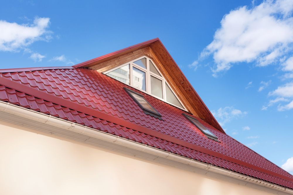 Red Metal Roof With Dormer and Skylights Against a Blue Sky — Your Craftsmen in Toronto, NSW