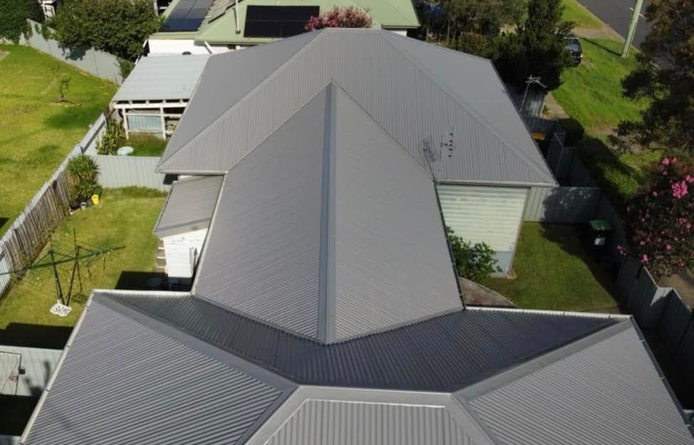 Overhead View of a House With a Gray Metal Roof, Surrounded by Green Grass and Other Houses — Your Craftsmen in Eleebana, NSW