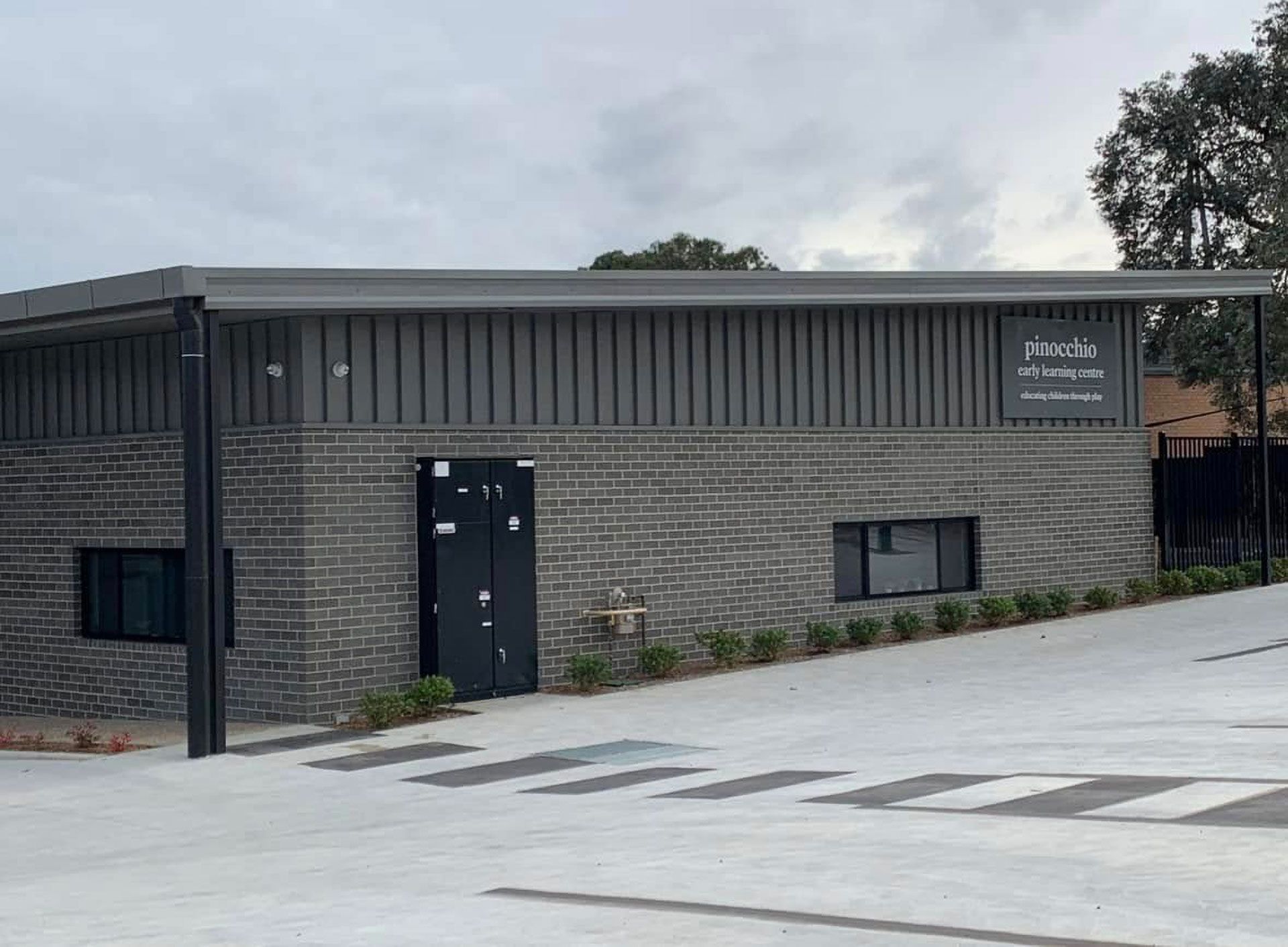 Gray Brick Building With Sign and Paved Area, Cloudy Sky Background — Your Craftsmen in Cessnock, NSW