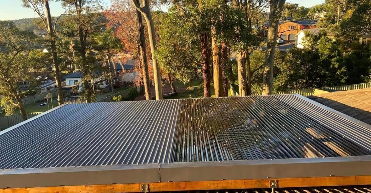 Corrugated metal roof, reflecting trees and sky, viewed from above. — Your Craftsmen in Maitland, NSW