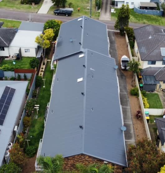 Aerial View of a Gray Roofed Building With a Boat Parked Nearby in a Residential Area — Your Craftsmen in Eleebana, NSW