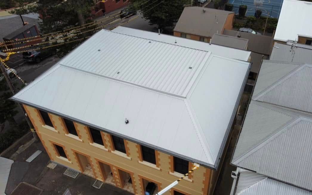 Overhead View of a Two-story Brick Building With a White Metal Roof, in an Urban Setting — Your Craftsmen in Eleebana, NSW