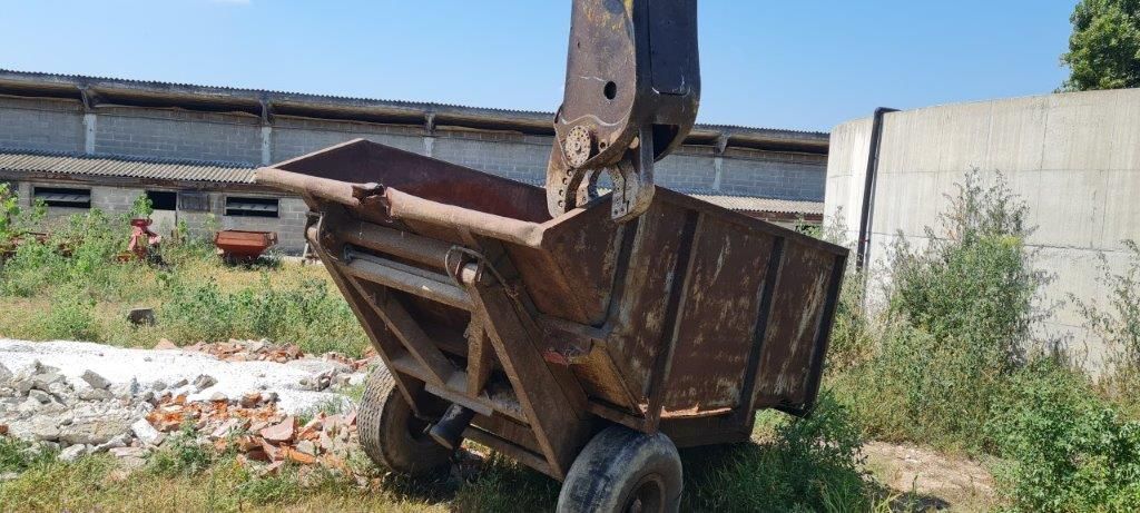Un vecchio autocarro con cassone ribaltabile arrugginito è parcheggiato in un campo.