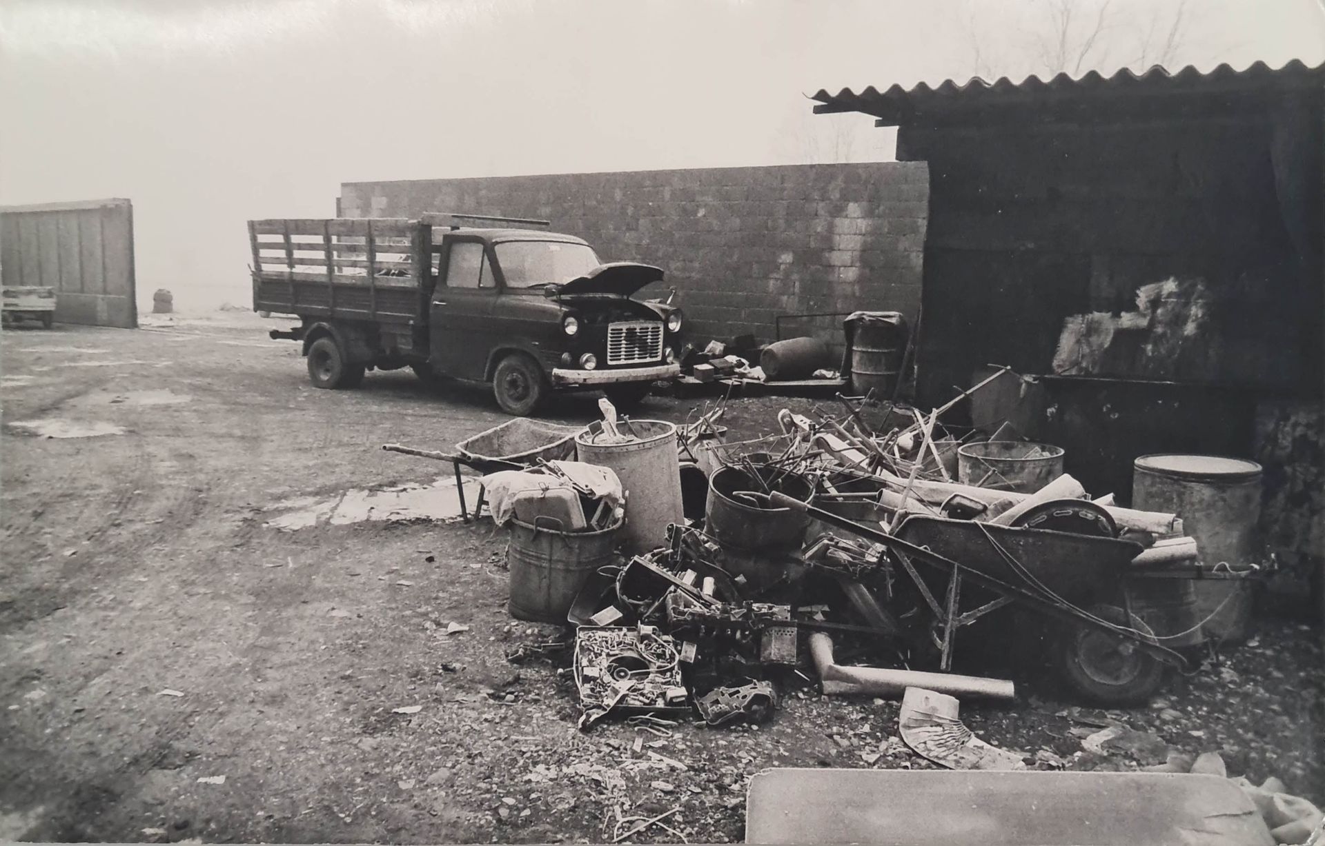 Una foto in bianco e nero di un camion in un cortile