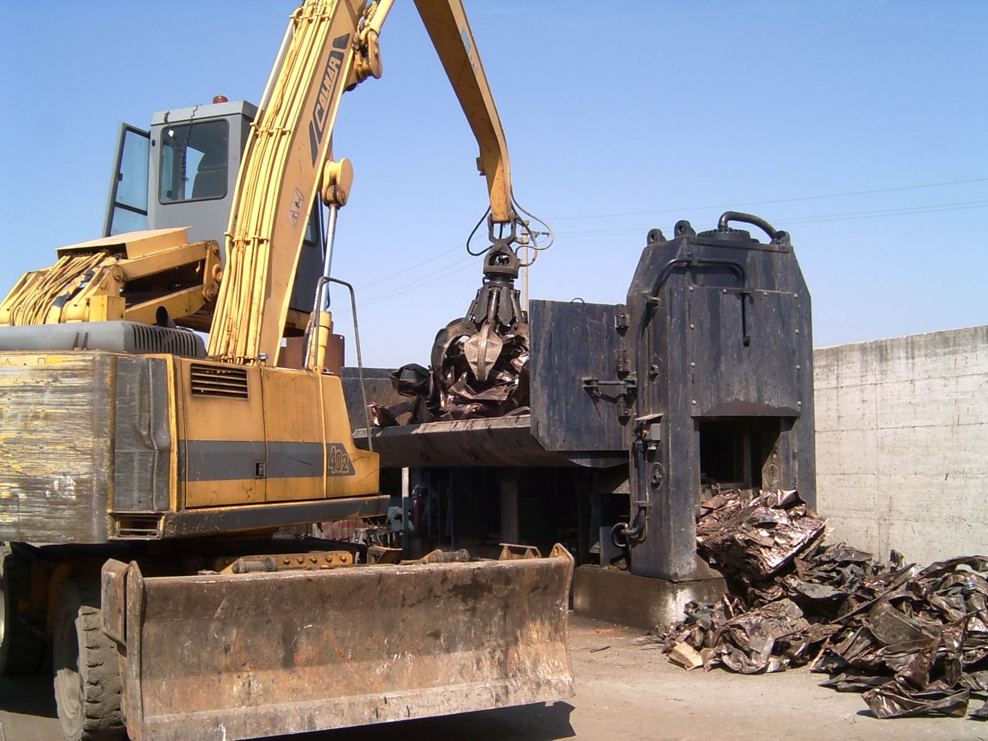 Un escavatore giallo con una gru attaccata