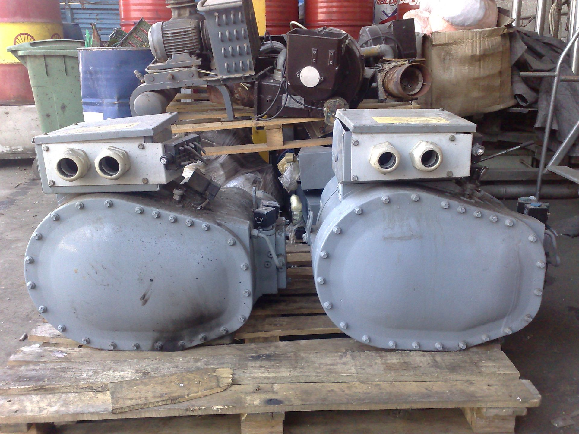 Due pezzi di metallo sono appoggiati su un pallet di legno.