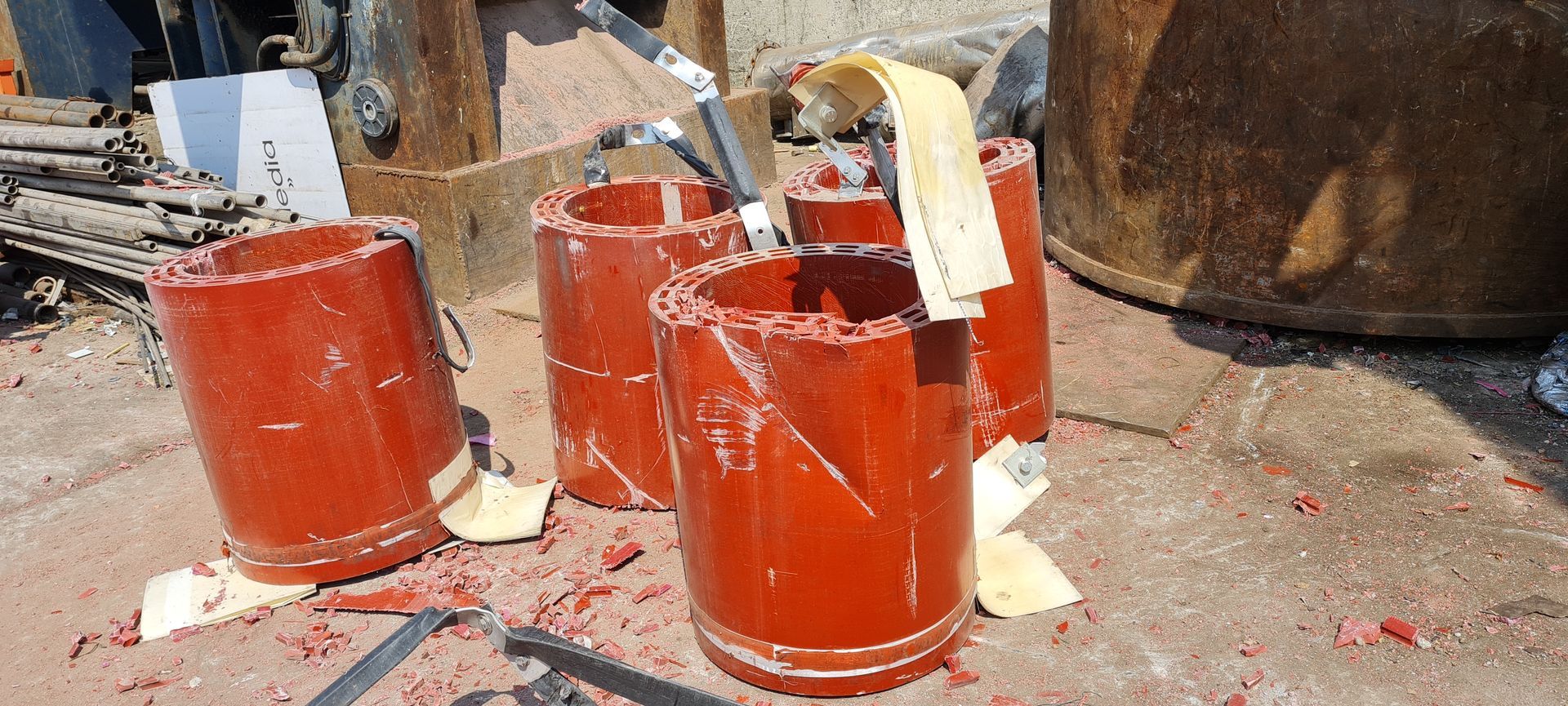 Un gruppo di secchi rossi è seduto a terra.