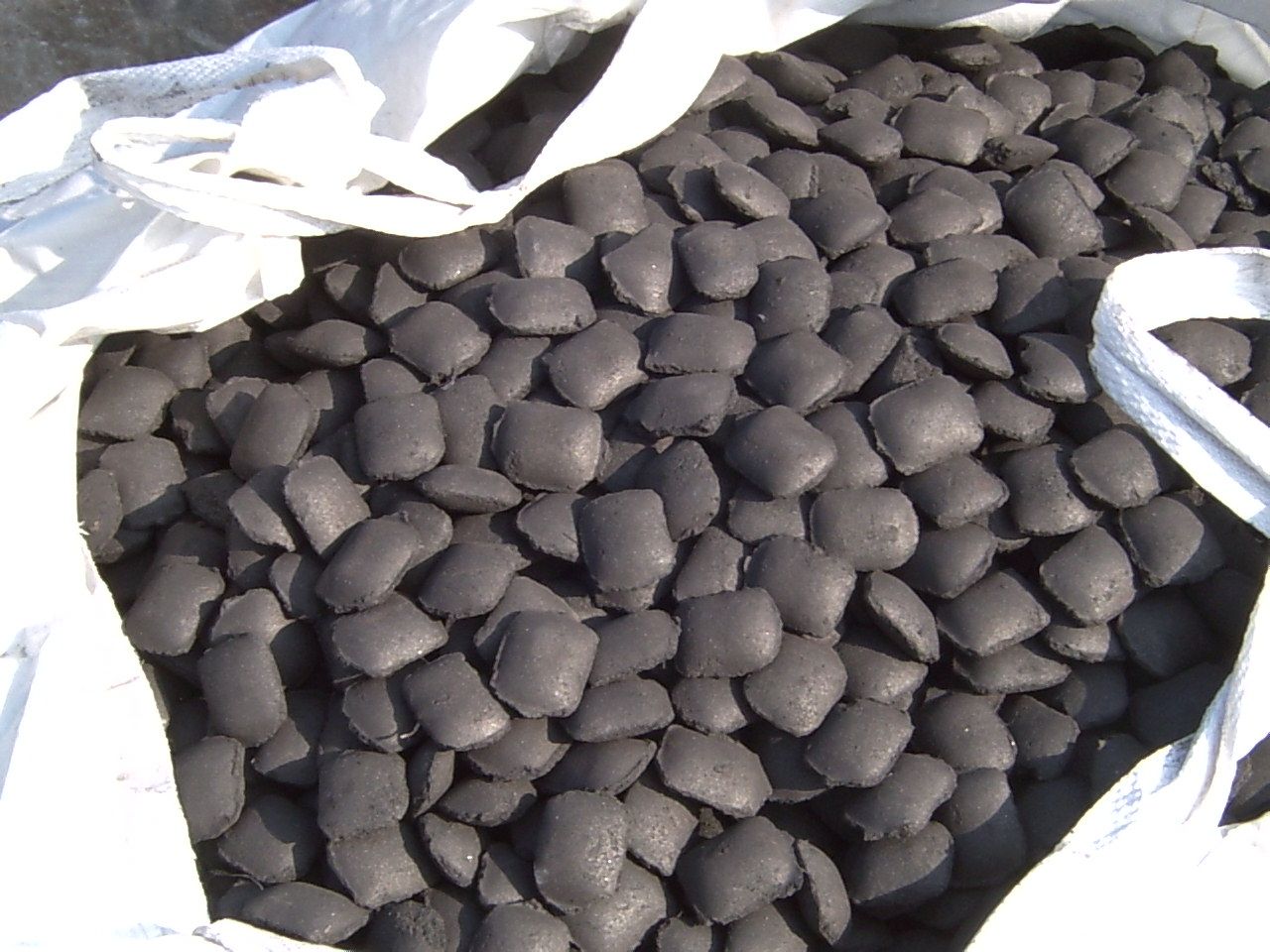 Un mucchio di carbone è seduto in un sacchetto bianco