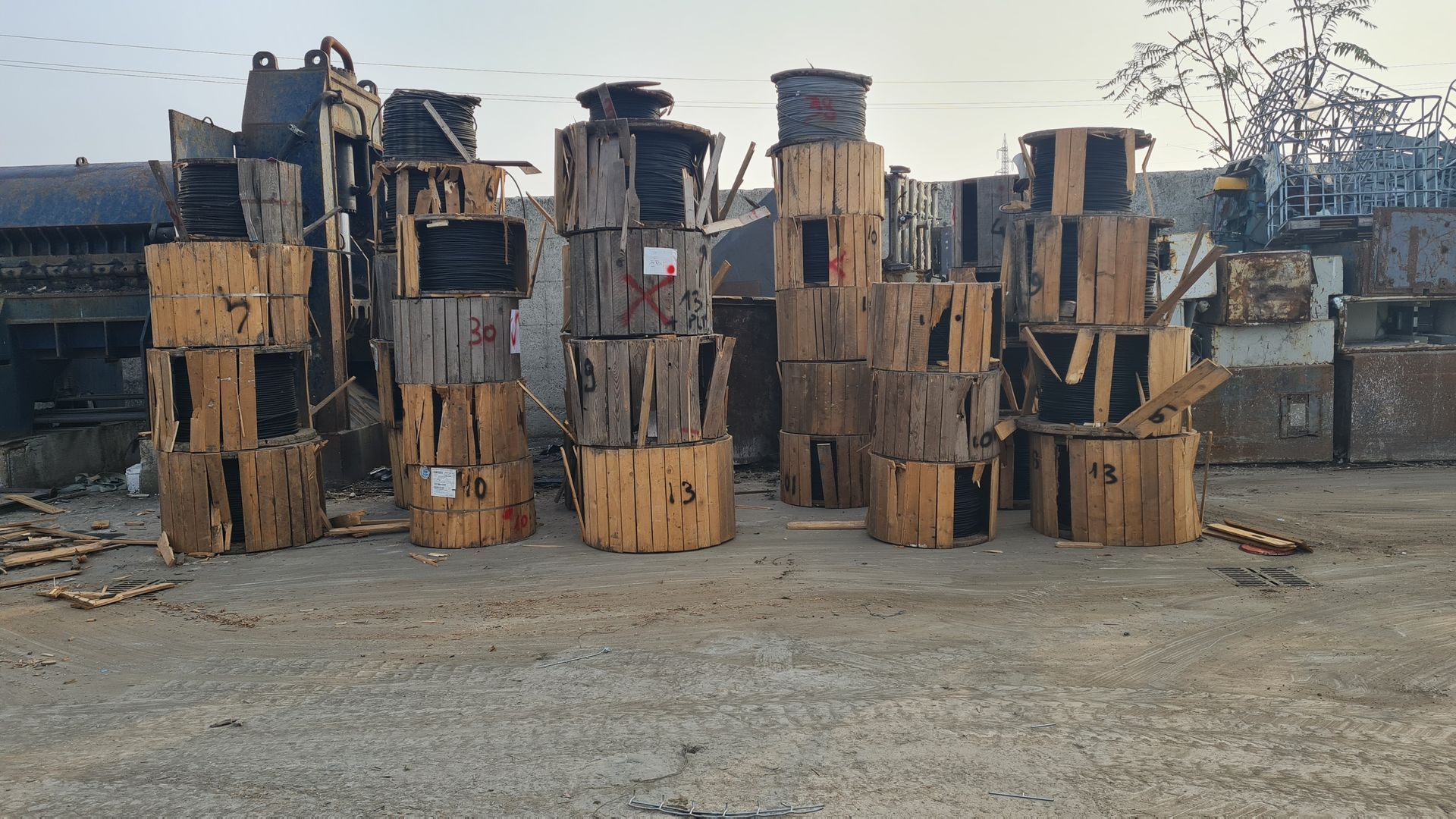 Un mucchio di casse di legno sono impilate una sull'altra in un cortile.