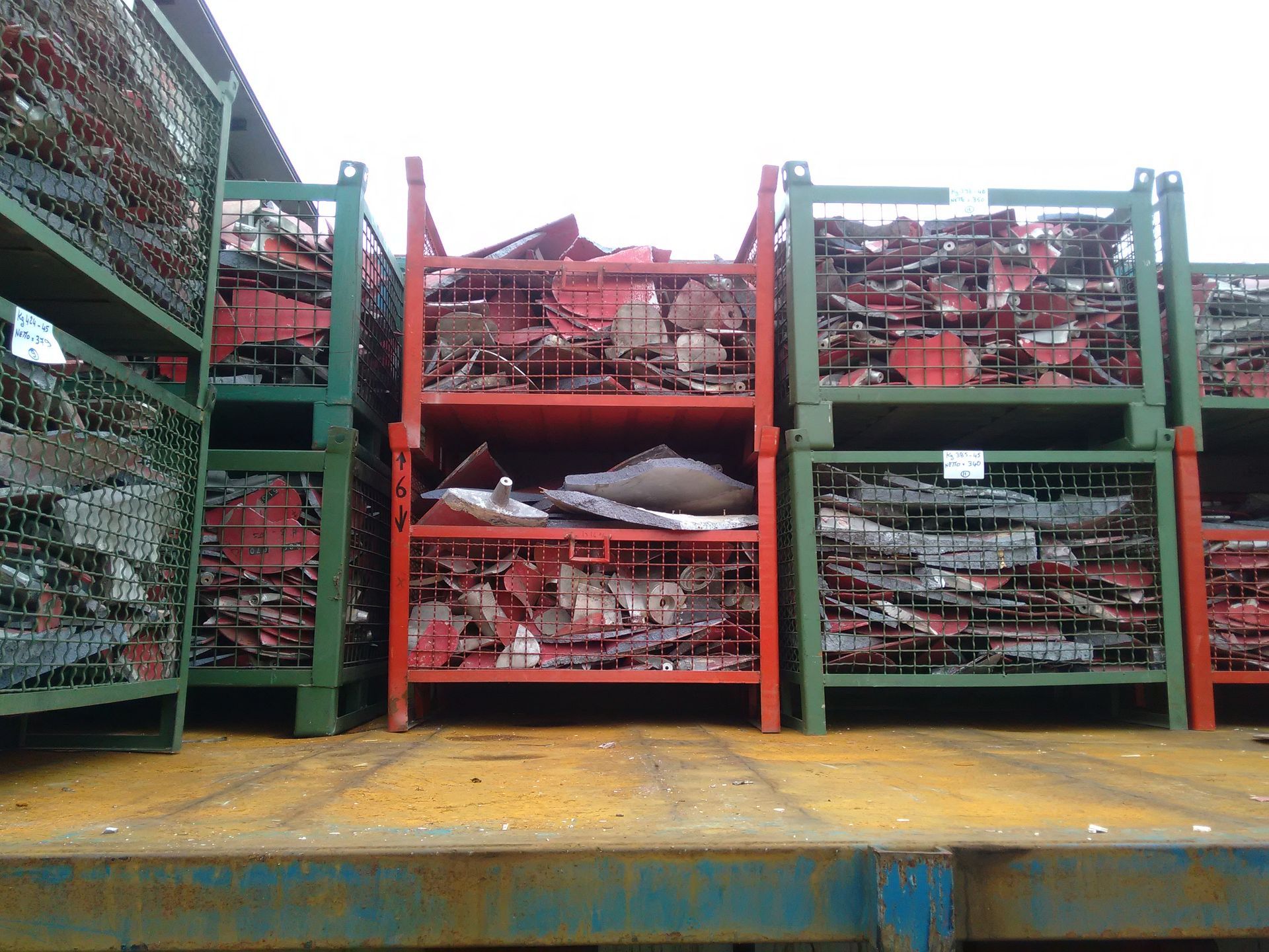 Una pila di casse metalliche piene di rottami metallici.