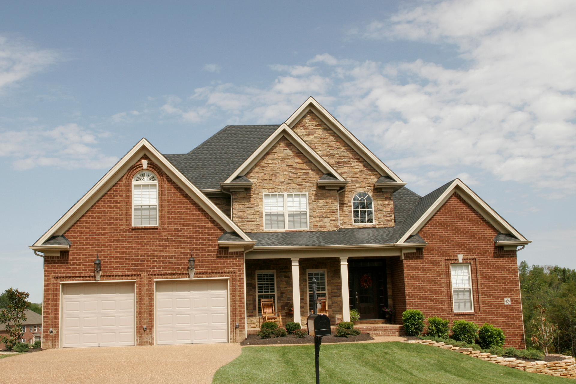 A large brick house with a mailbox in front of it