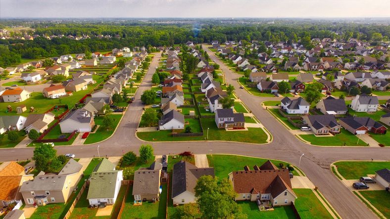 An aerial view of a residential neighborhood with lots of houses and trees.