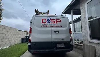 White service van with D&SP logo parked in a narrow driveway beside a house.