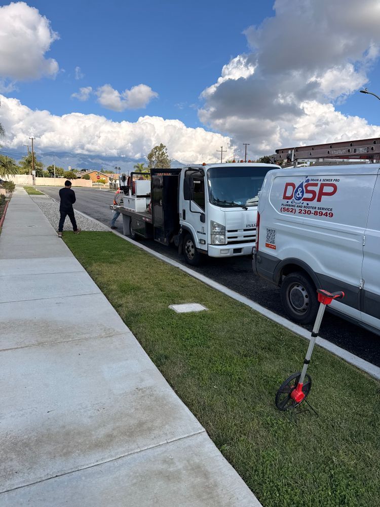 Workers unloading boxes from a white delivery truck on a suburban sidewalk under a cloudy sky