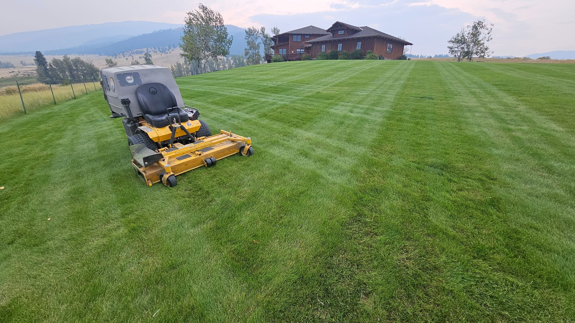 Walker mower parked on a freshly cut beautifully manicured lawn.