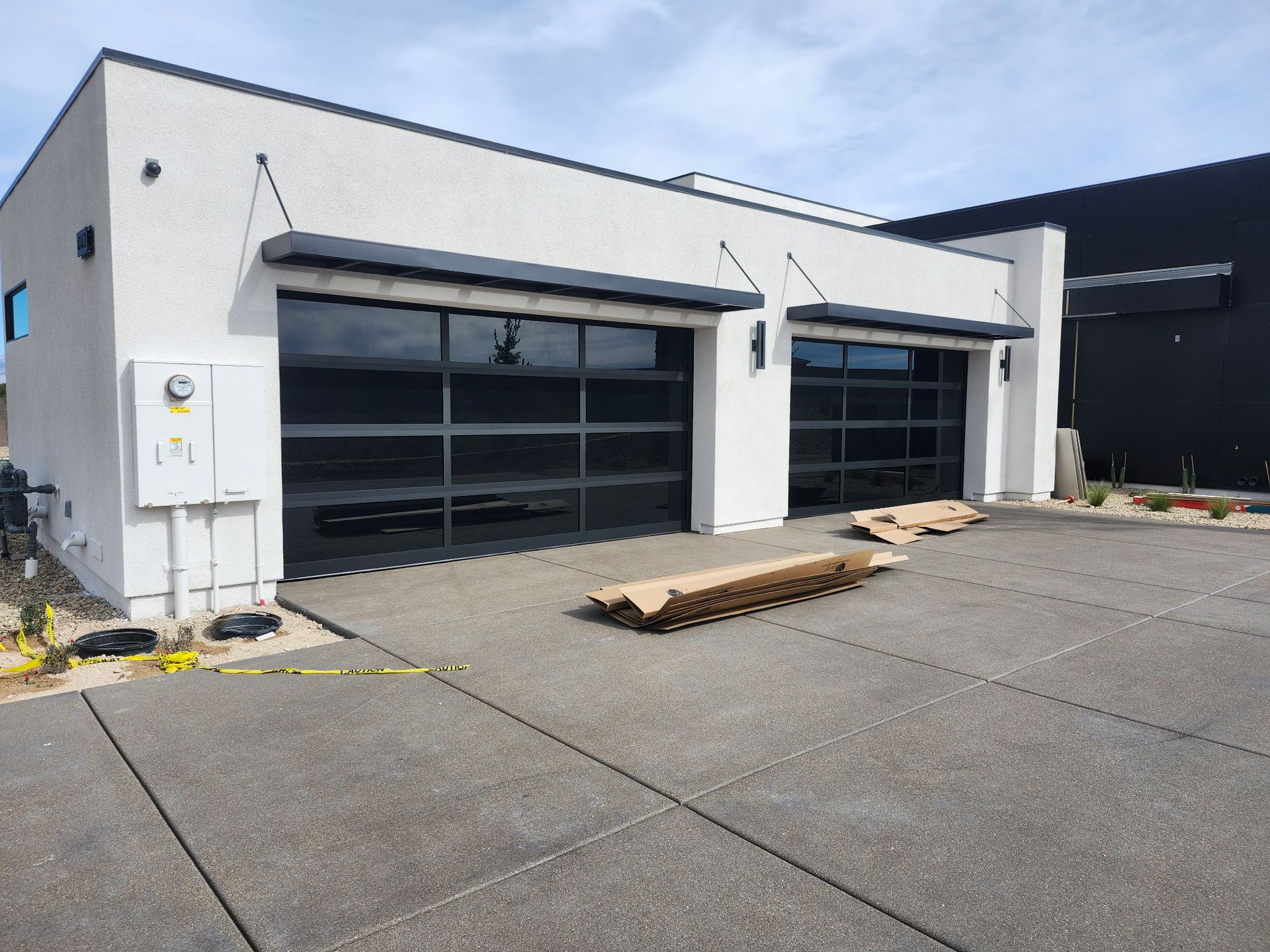 A white building with a black garage door is being built.