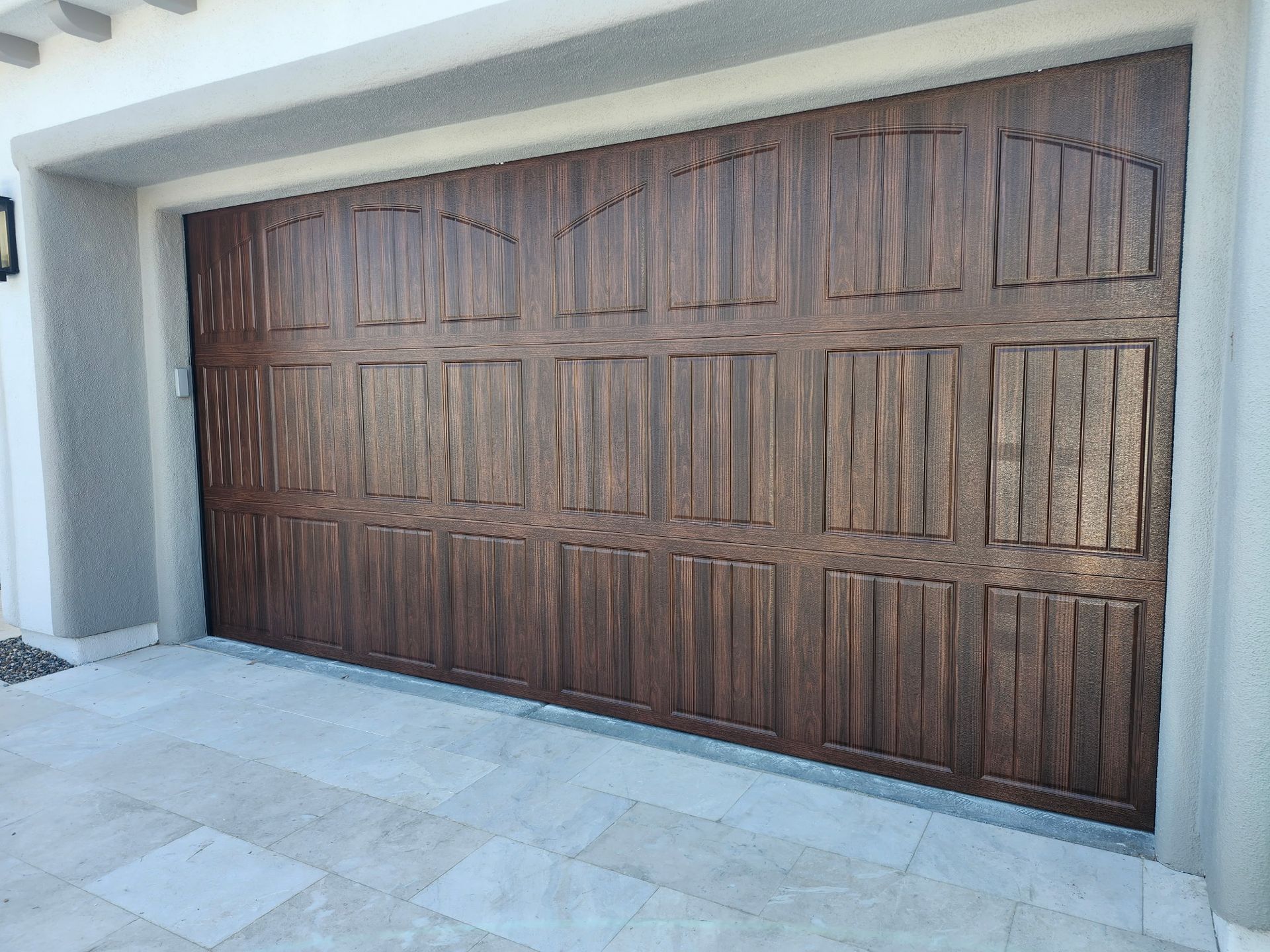 A large wooden garage door is sitting in front of a house.