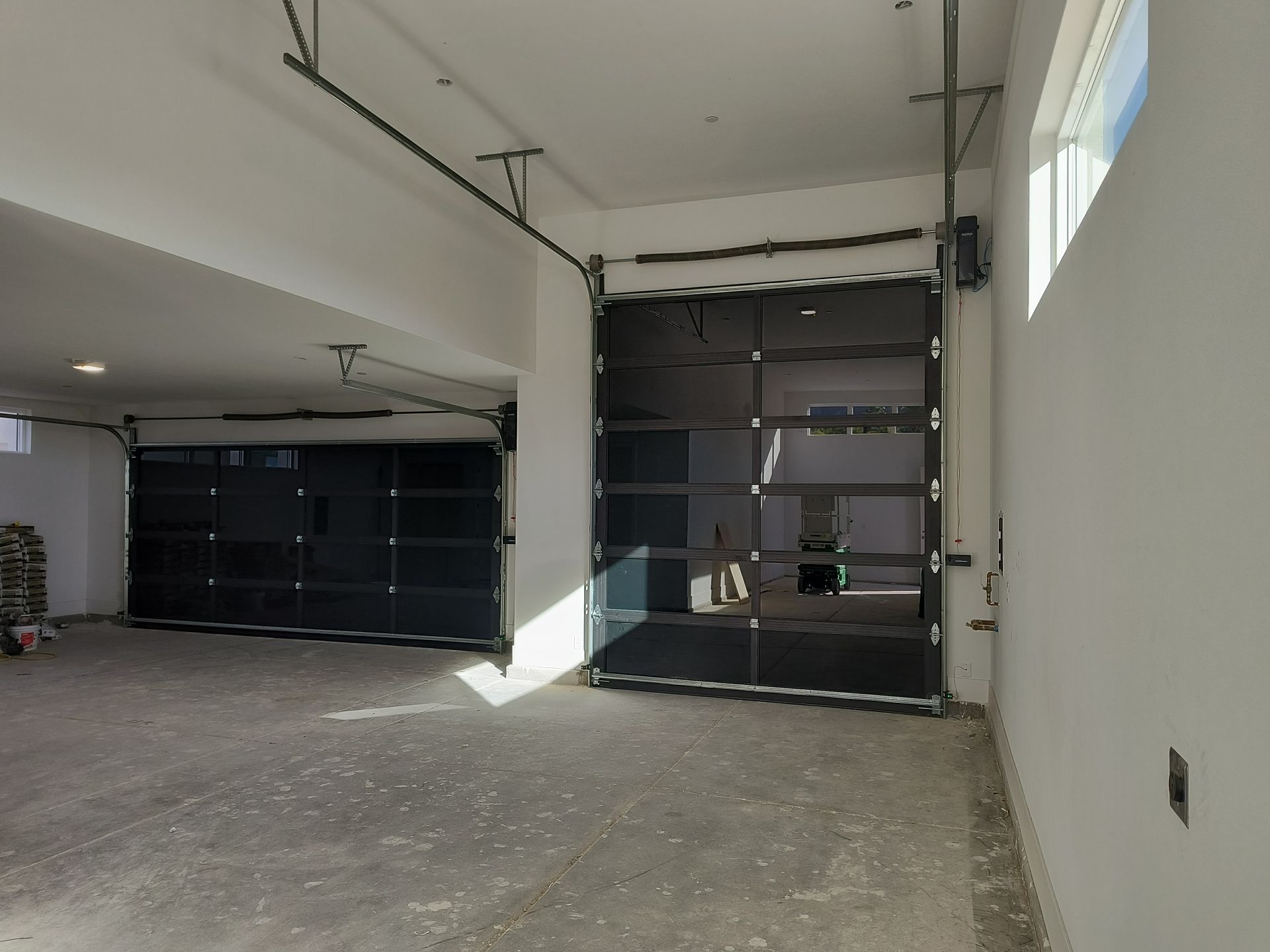 An empty garage with a black garage door and a window