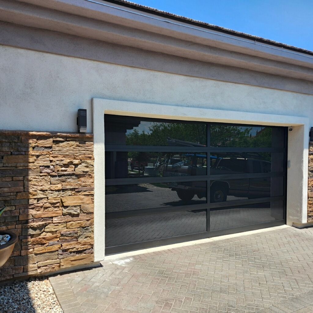 A car is parked in front of a glass garage door