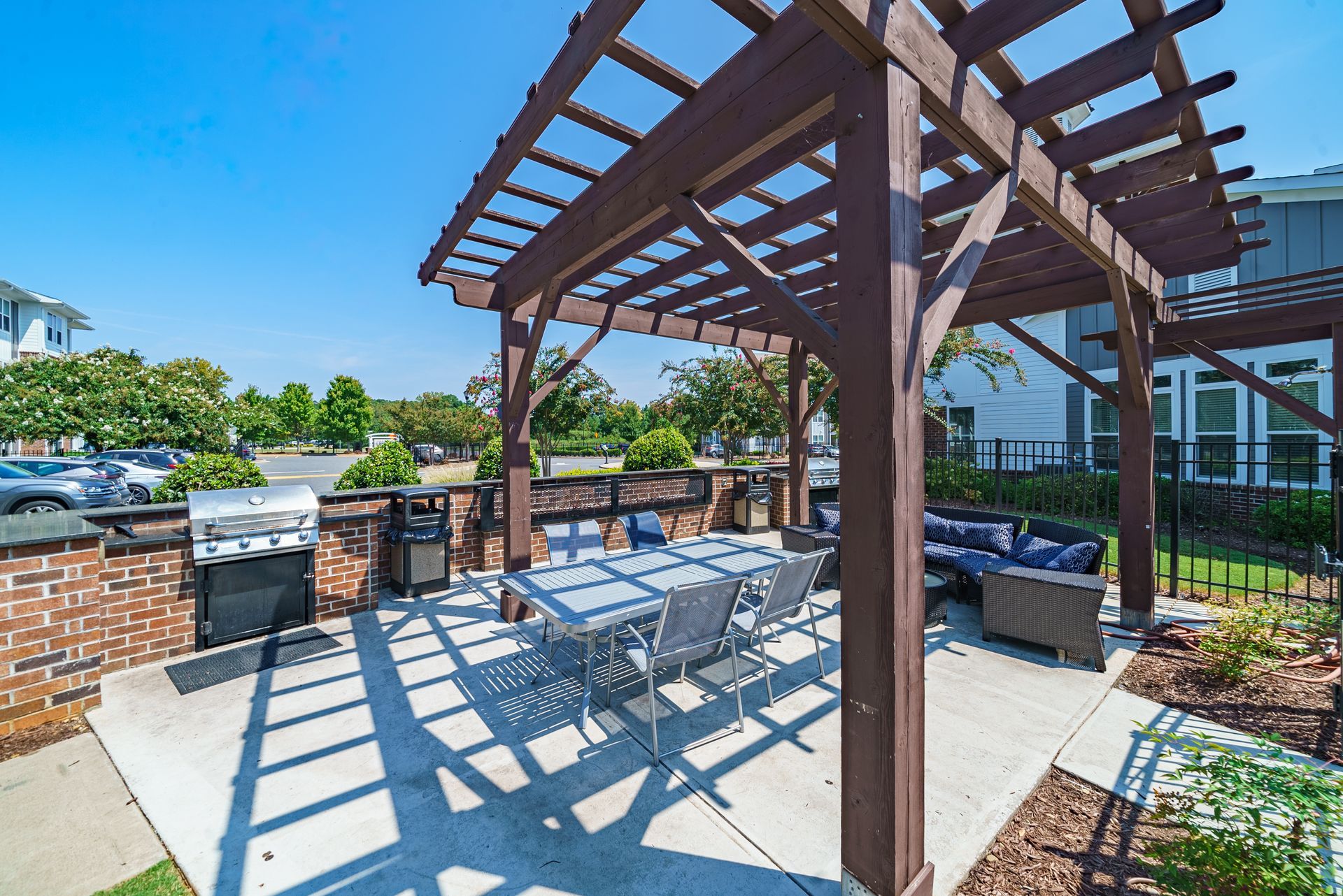 Outdoor patio with a pergola, a table with chairs, and a grill at Willows at Fort Mill, offers apartments for rent near I-77 in Fort Mill, SC.