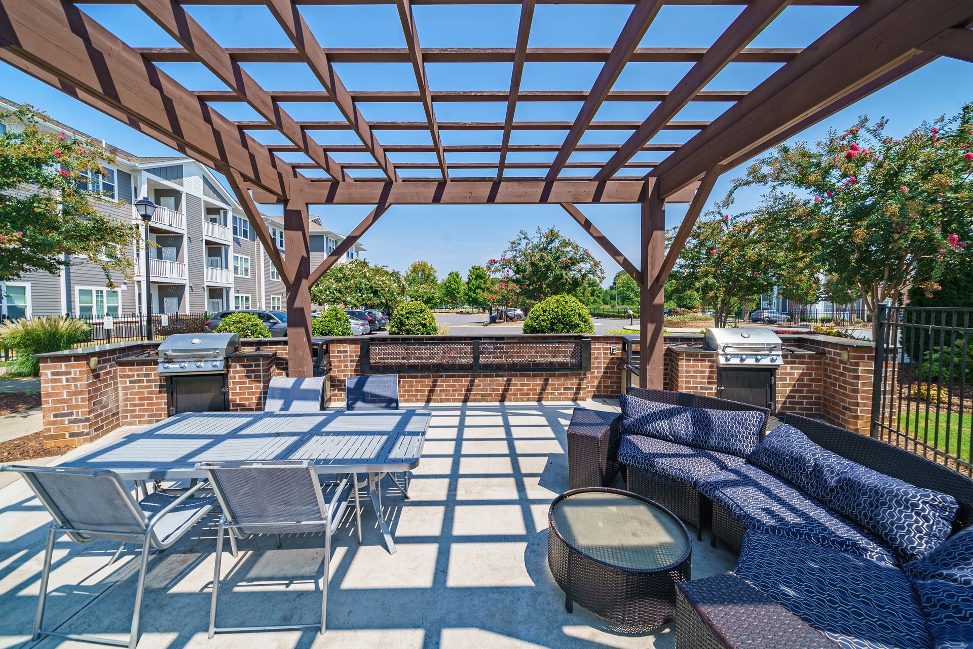 Outdoor patio with grills, seating, and pergola at Willows at Fort Mill, offers apartments near Downtown Fort Mill, SC.