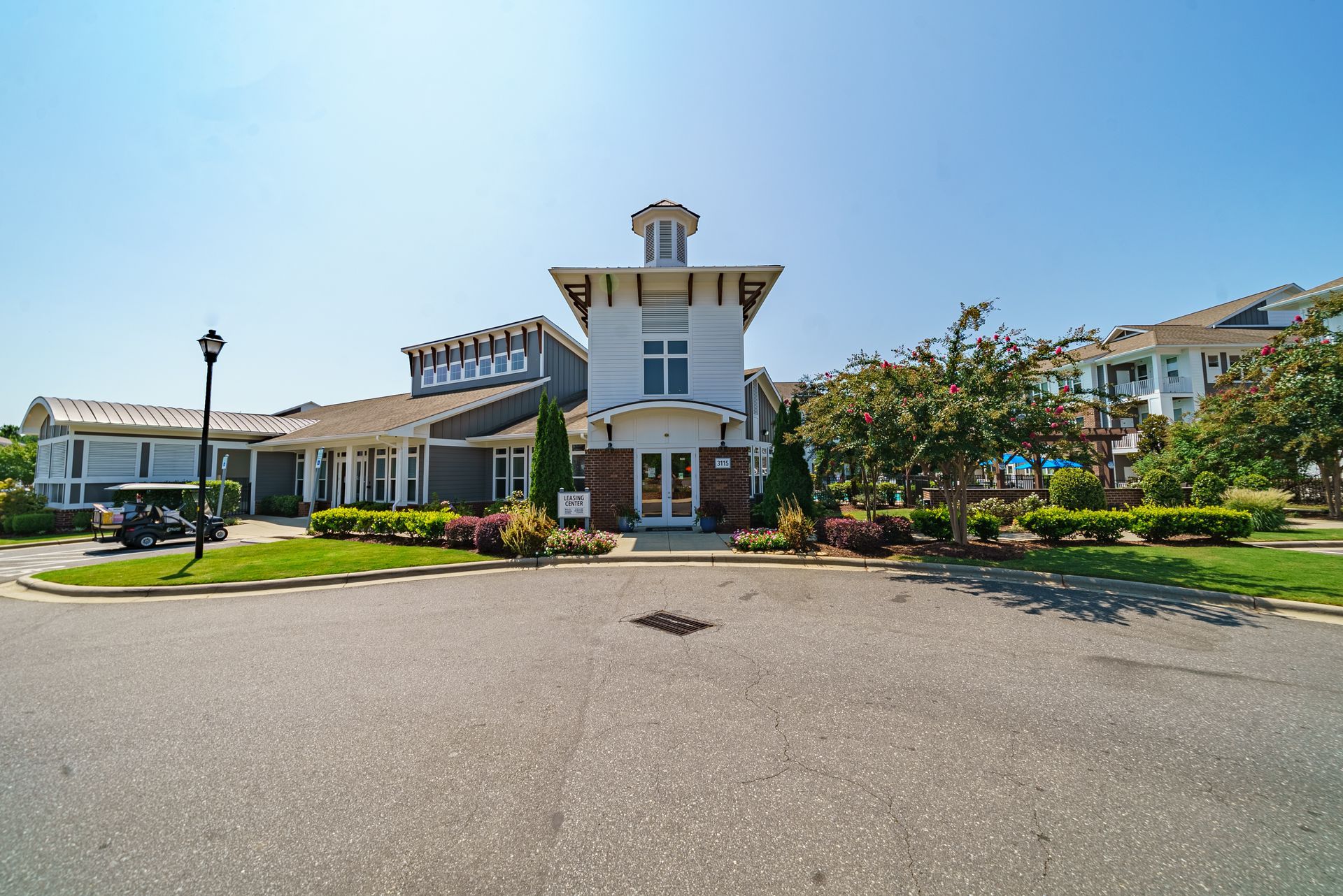 A white, lighthouse-style building with a paved area in front and landscaping at Willows at Fort Mill, offers apartments for rent in Fort Mill, SC.