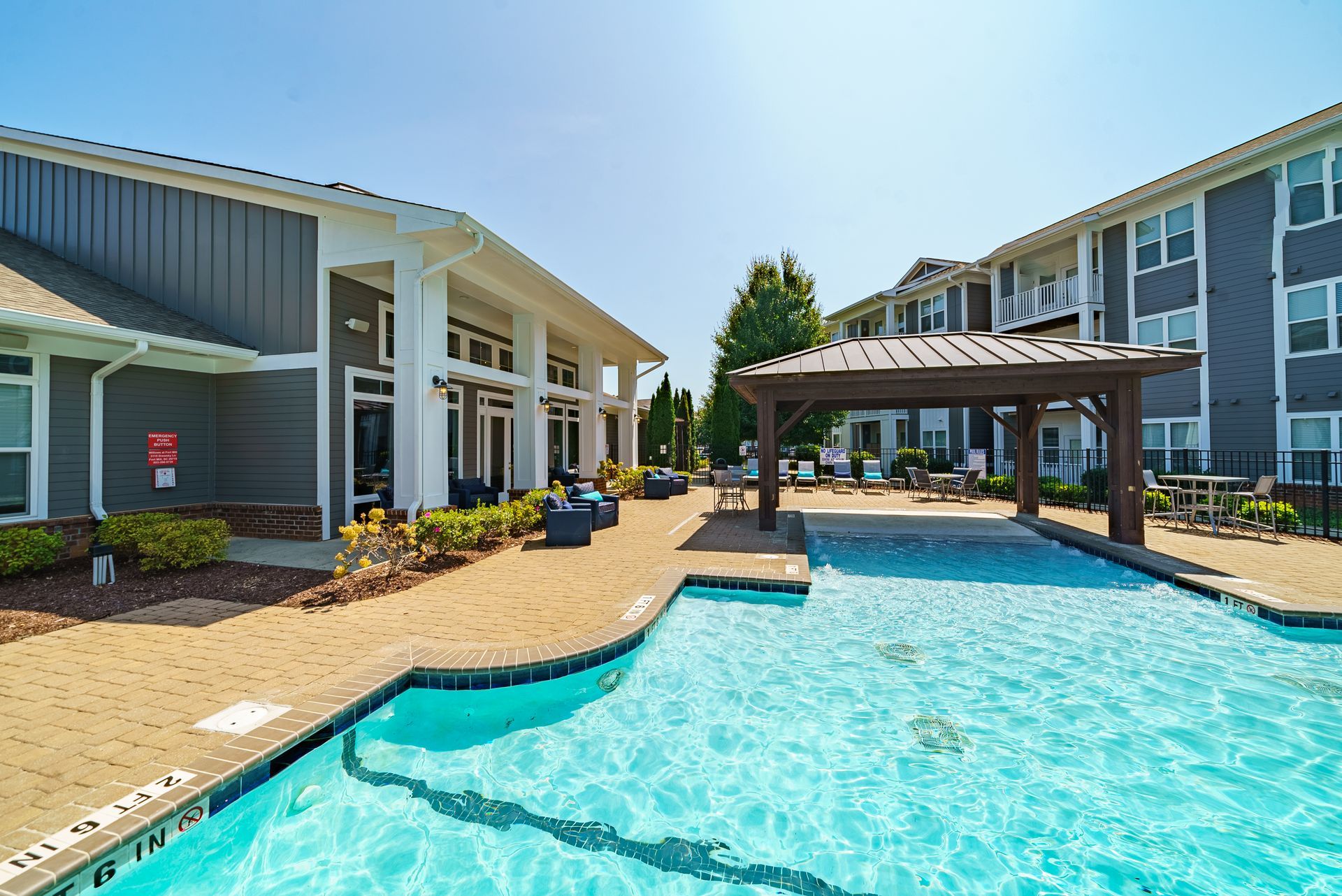 Swimming pool with buildings, patio, and pergola. Sunny, outdoor setting at Willows at Fort Mill, offers 1, 2, and 3 bedroom apartments for rent in Fort Mill, SC.