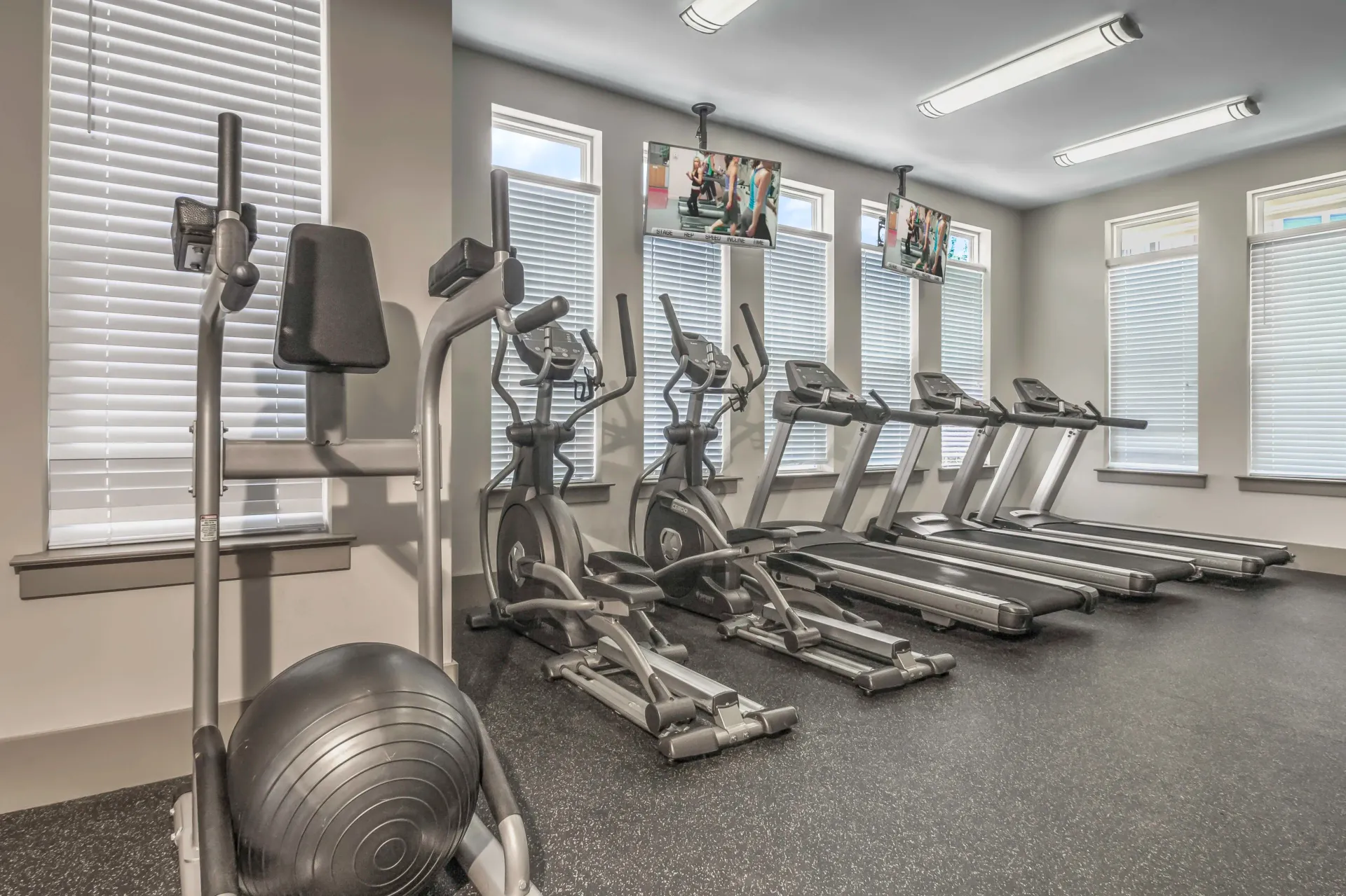 Gym with exercise equipment: ellipticals, treadmills, and exercise ball, near windows with white blinds at Willows at Fort Mill, offers 1,2, and 3 bedroom apartments for rent near Uptown Charlotte in Fort Mill, SC.