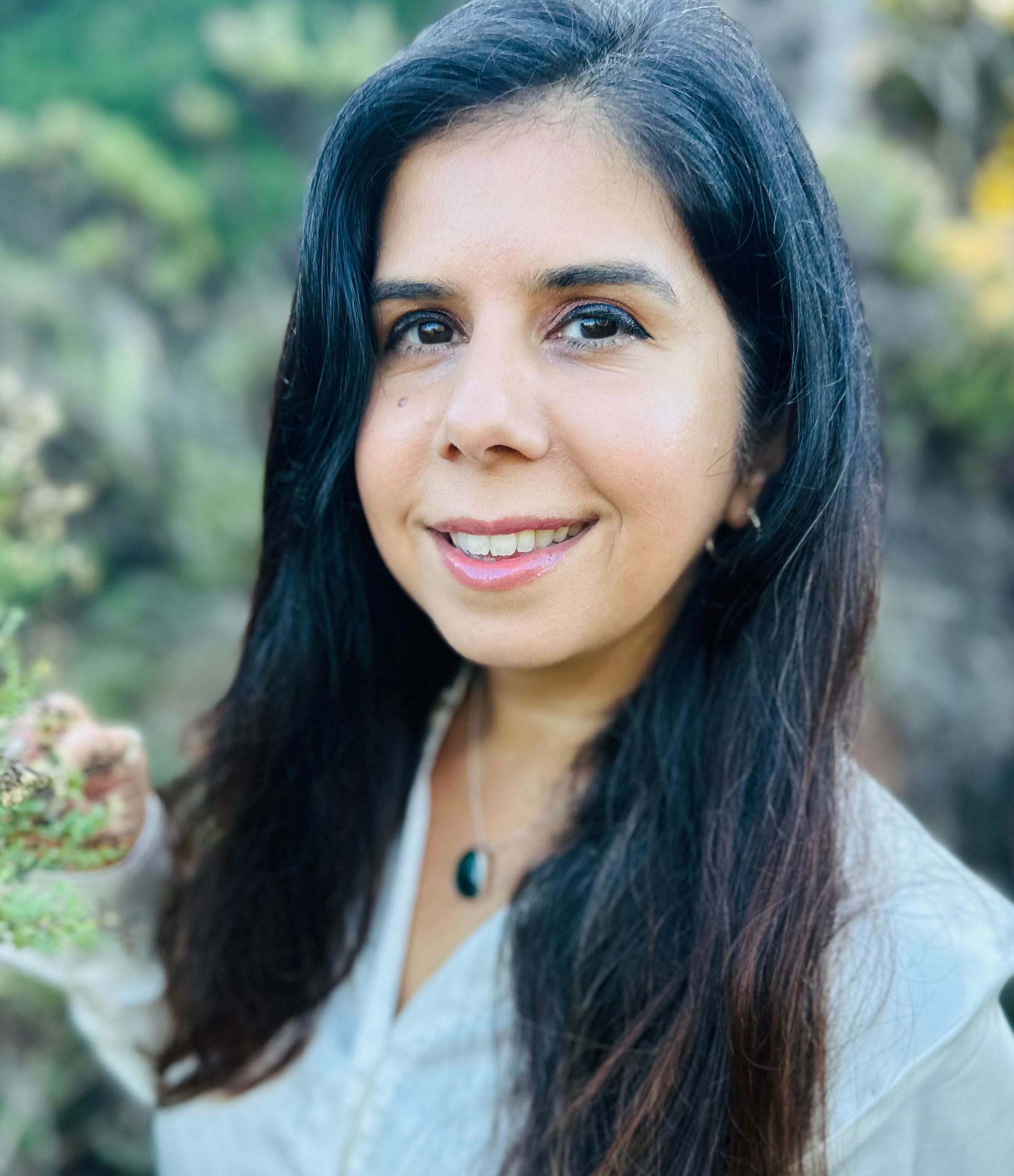 A woman with a warm smile in nature.