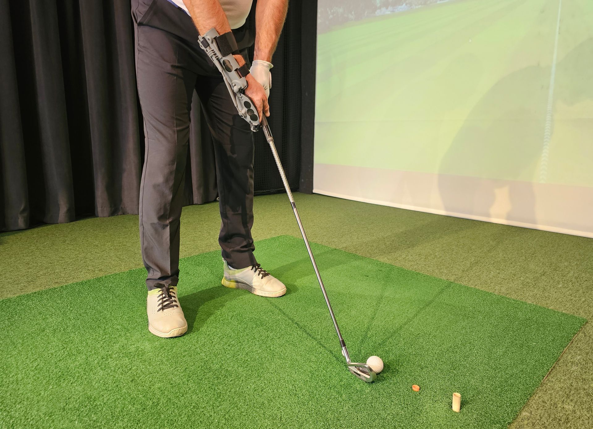 A man is swinging a golf club at a golf ball.