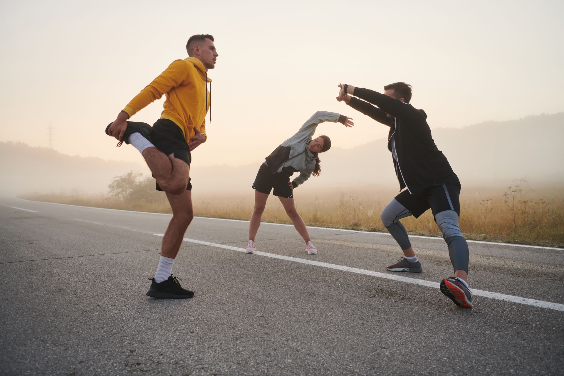 A group of people are stretching on the side of a road.