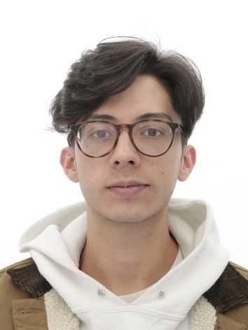 A young man wearing glasses and a hoodie is posing for a picture.