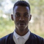 A man wearing headphones is taking a selfie on a track.