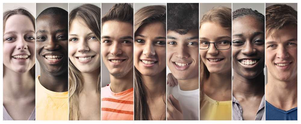 A group of young people are smiling in a row.