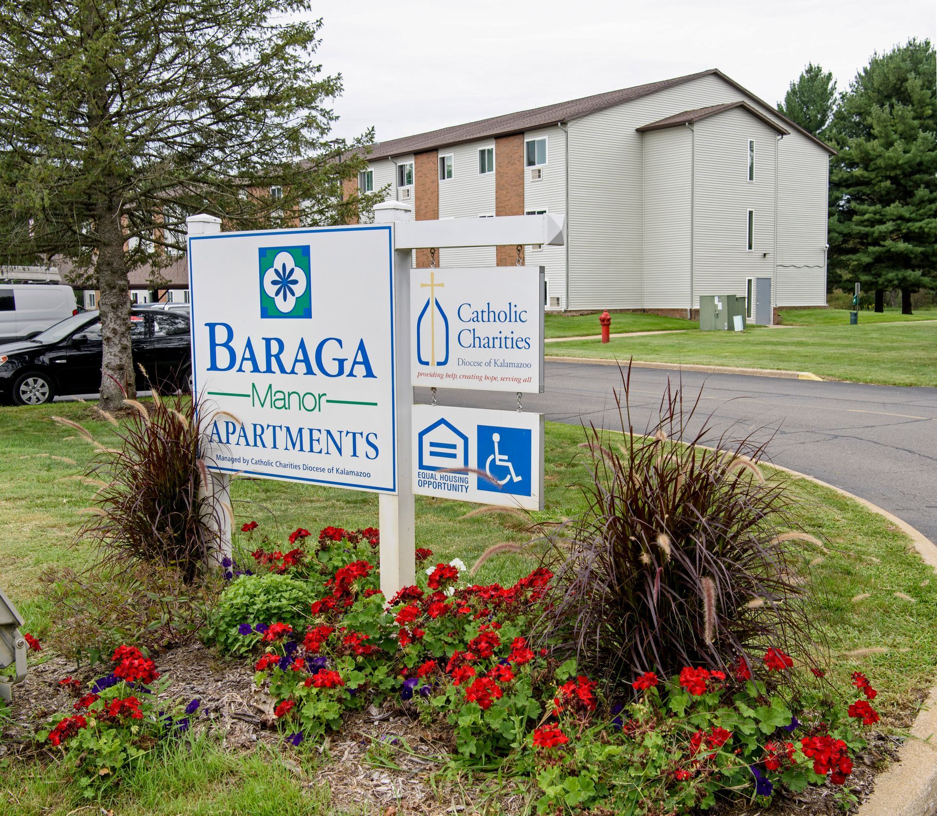 A sign for baraga apartments is in front of a building