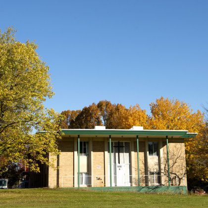 A house with a green roof and a cross on it