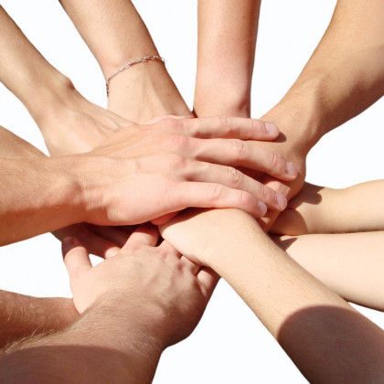 A group of people putting their hands together in a circle