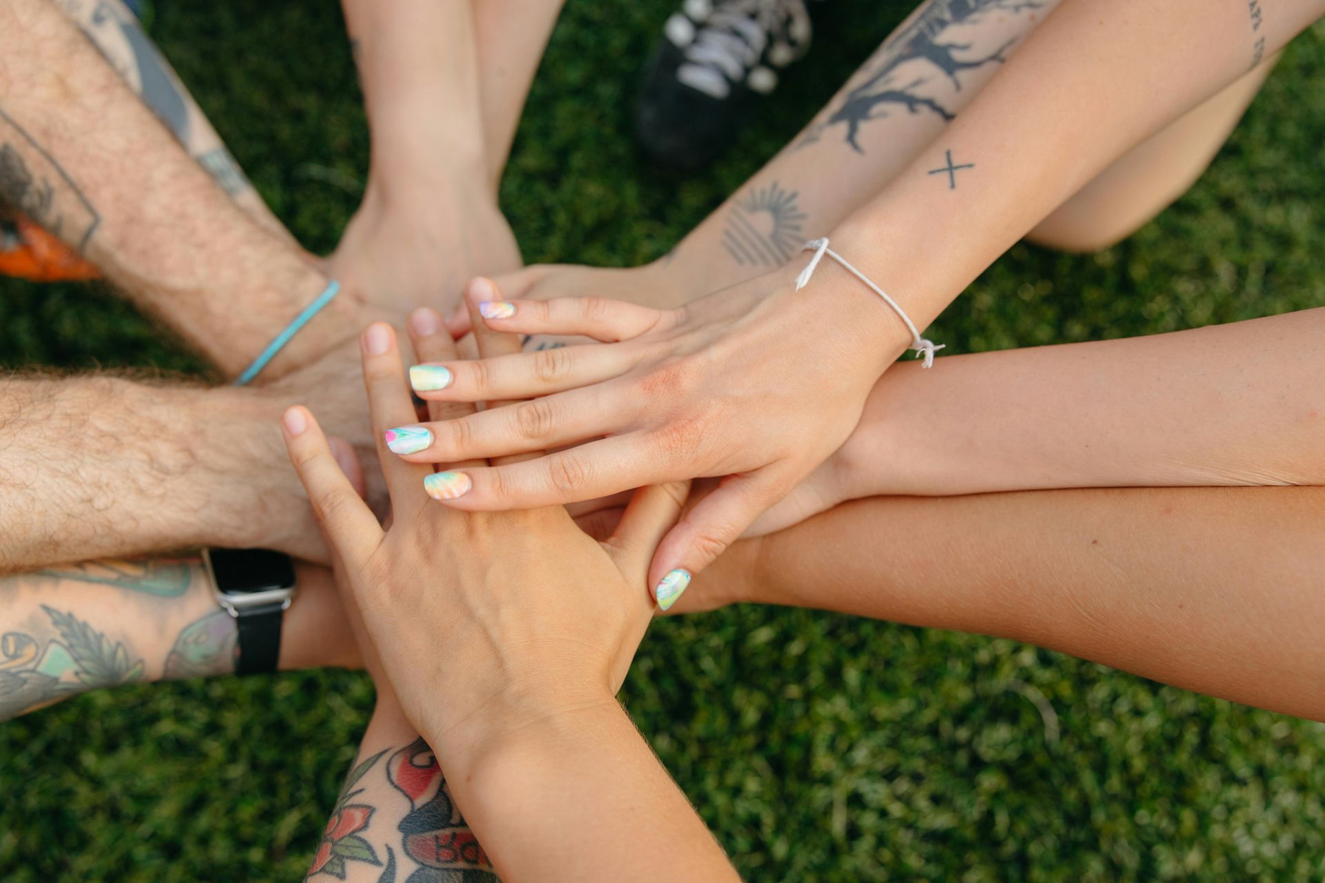 A group of people are putting their hands together in a circle.
