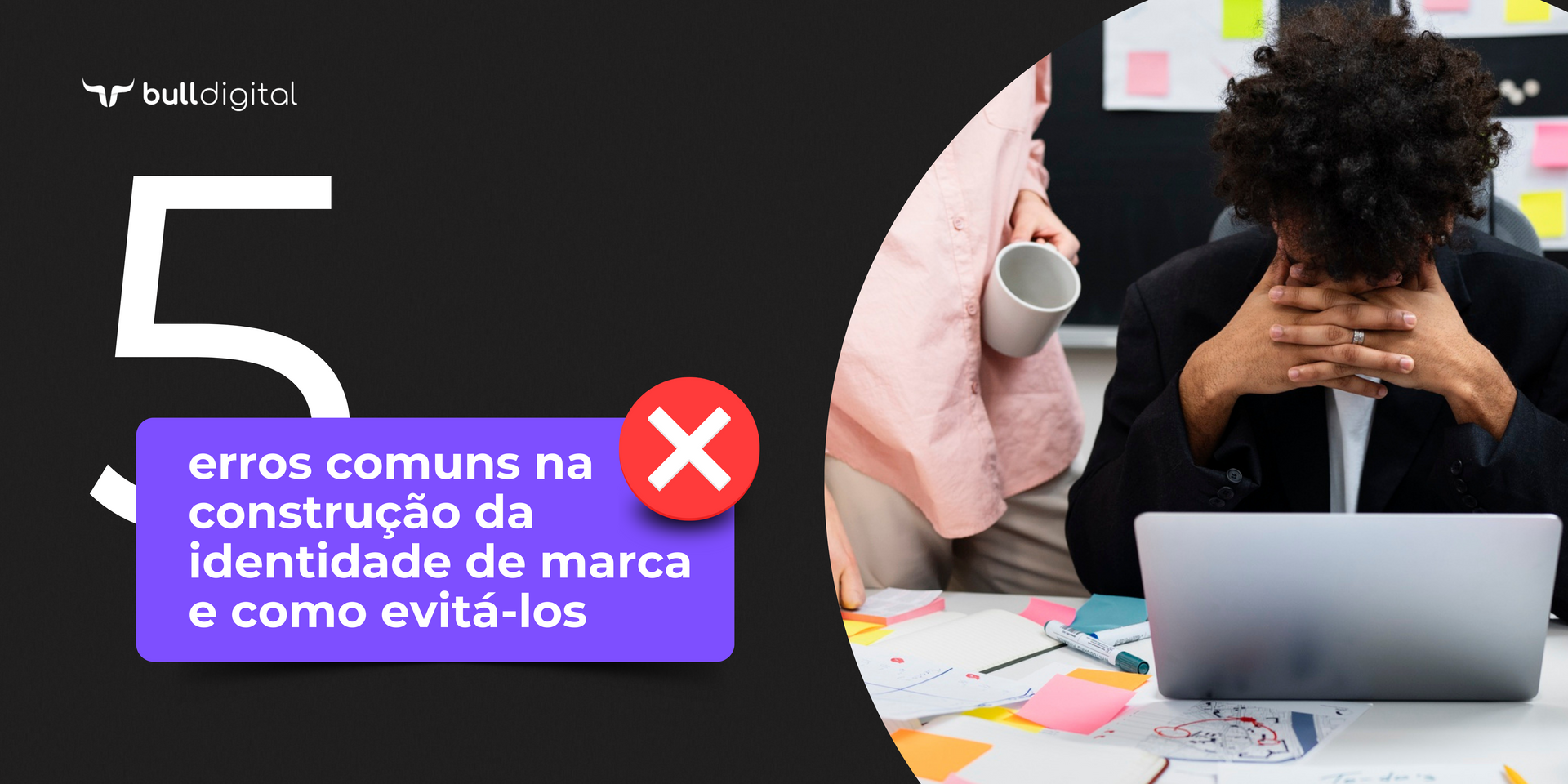 Um homem está sentado em frente a um laptop com a cabeça entre as mãos.