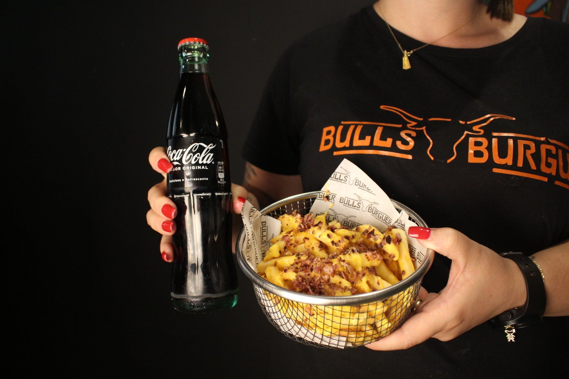 Uma mulher está segurando uma tigela de comida e uma garrafa de coca-cola.