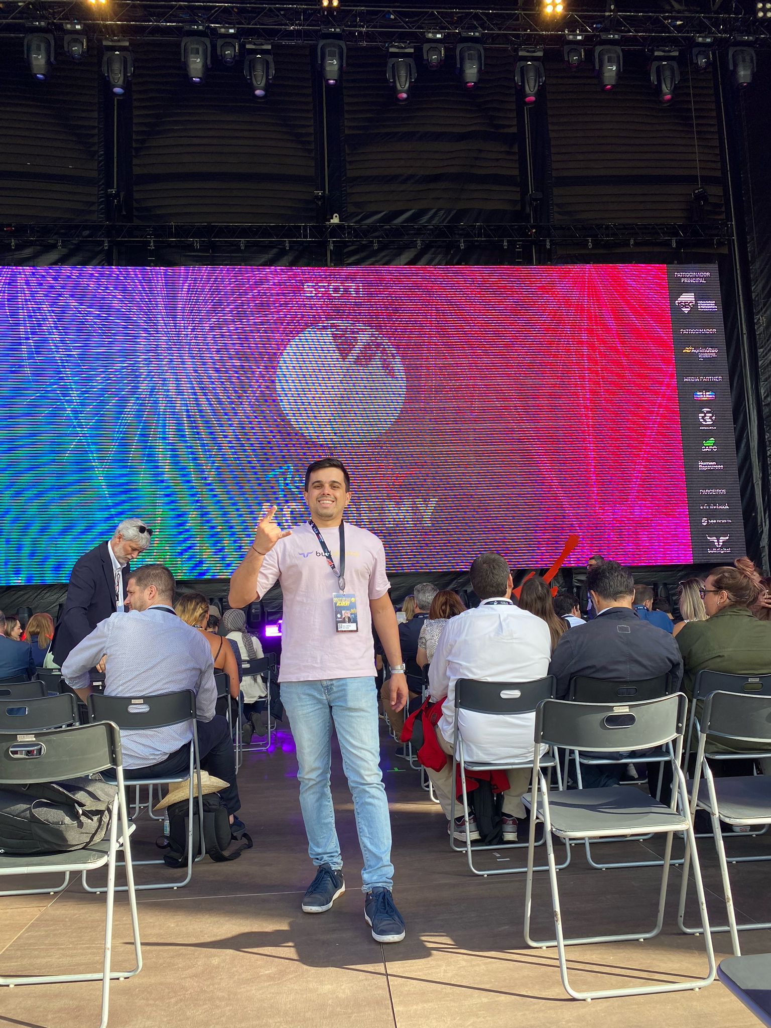 Um homem está diante de uma grande tela em um show.