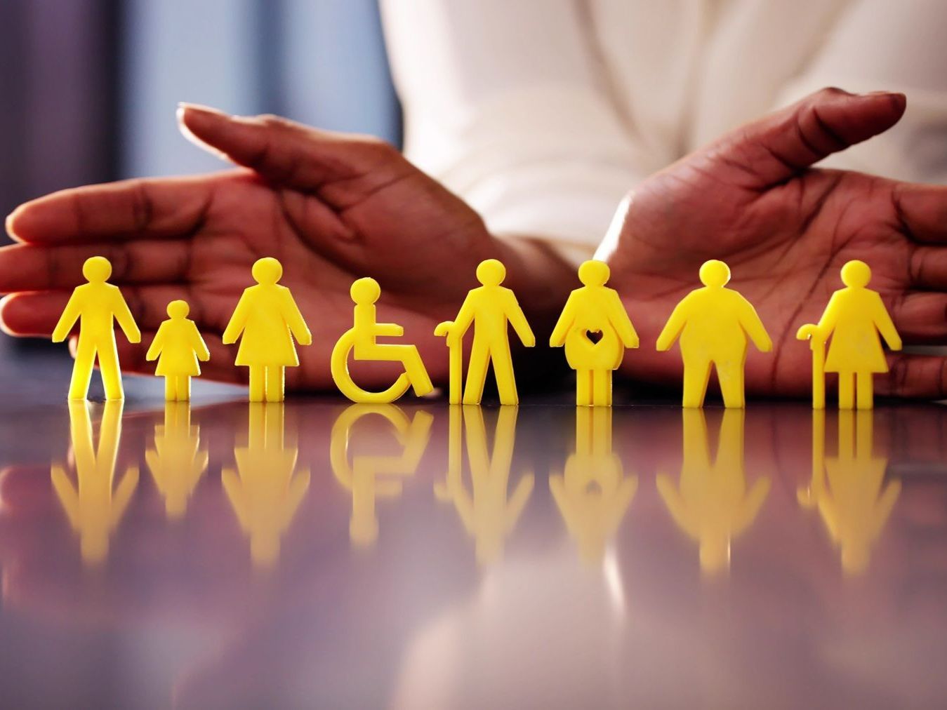 A person is holding a row of yellow paper people
