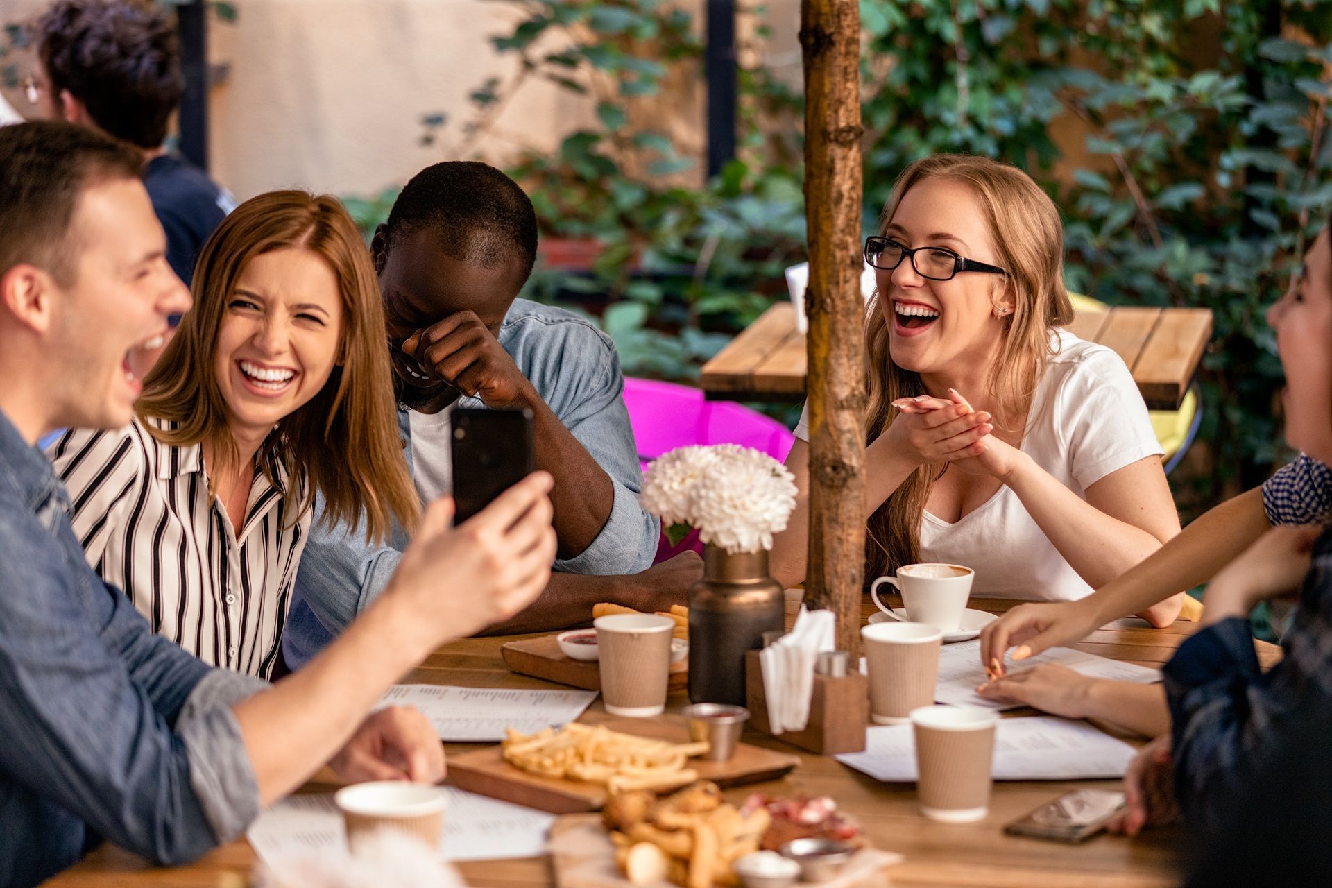 A group of people are sitting around a table laughing.
