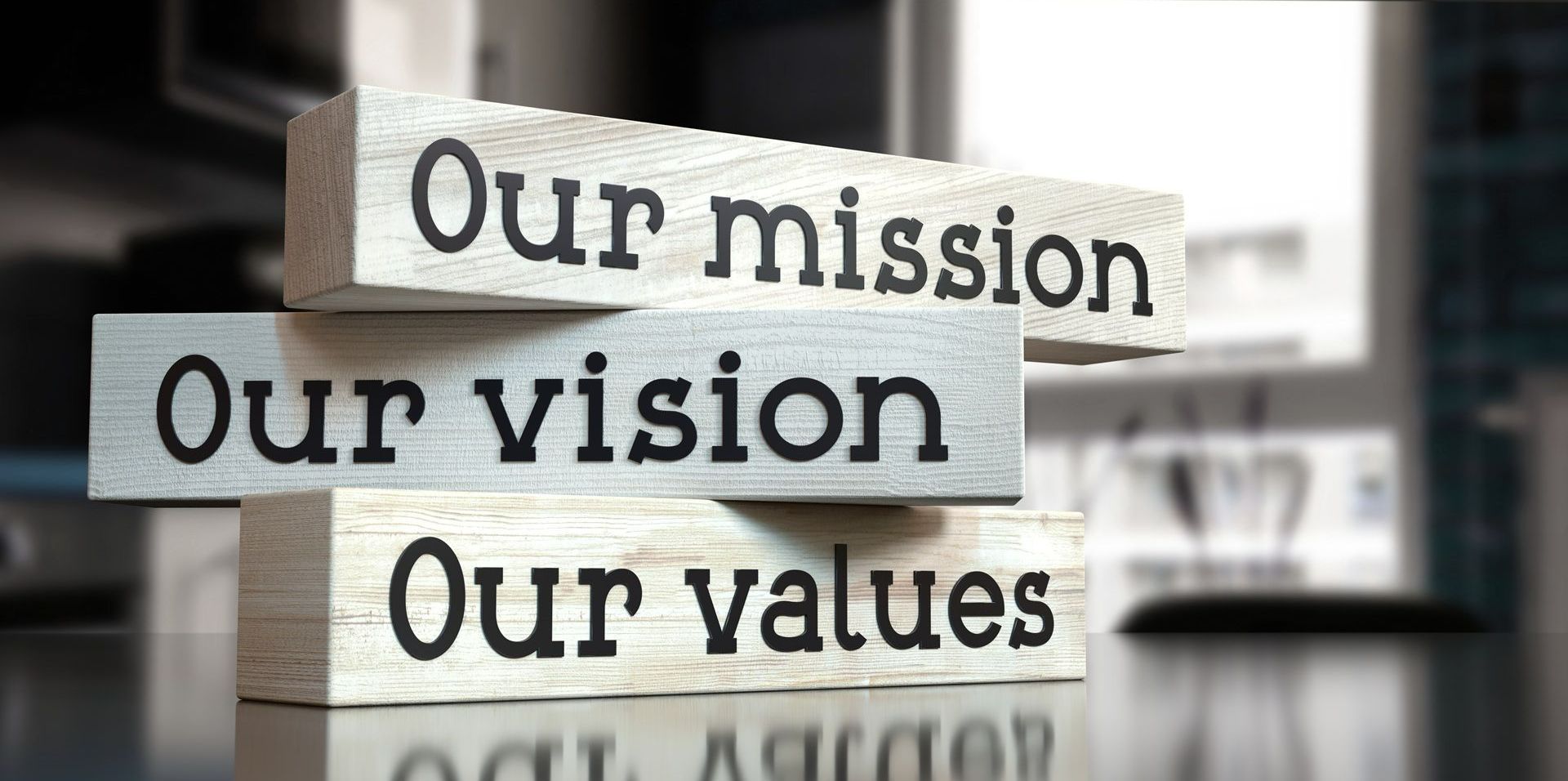 A stack of wooden blocks with the words `` our mission our vision our values '' written on them.