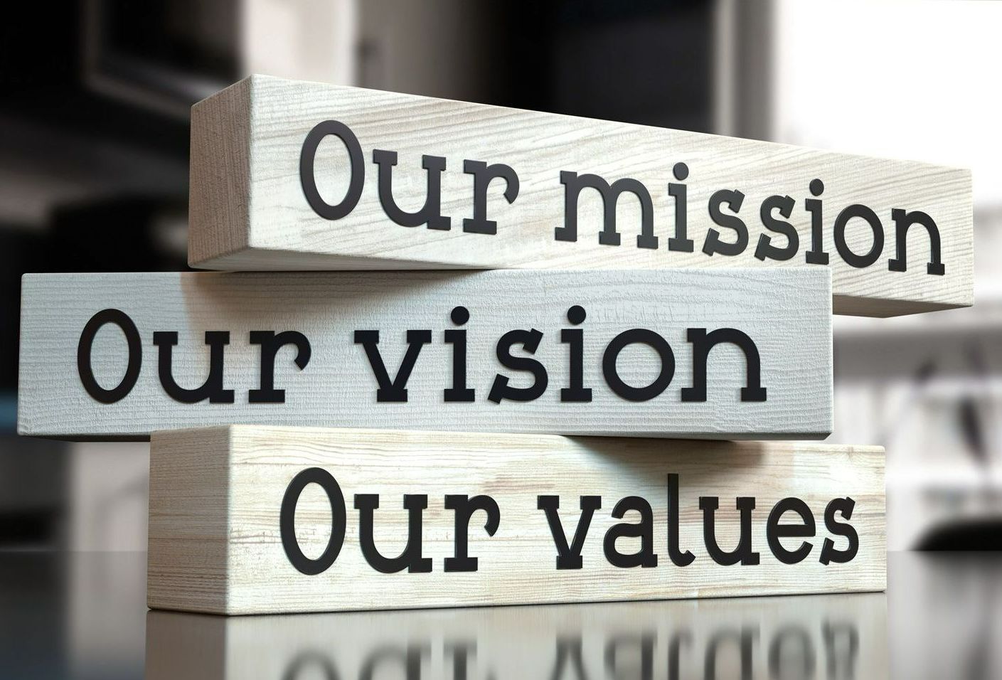 A stack of wooden blocks with the words `` our mission our vision our values '' written on them.
