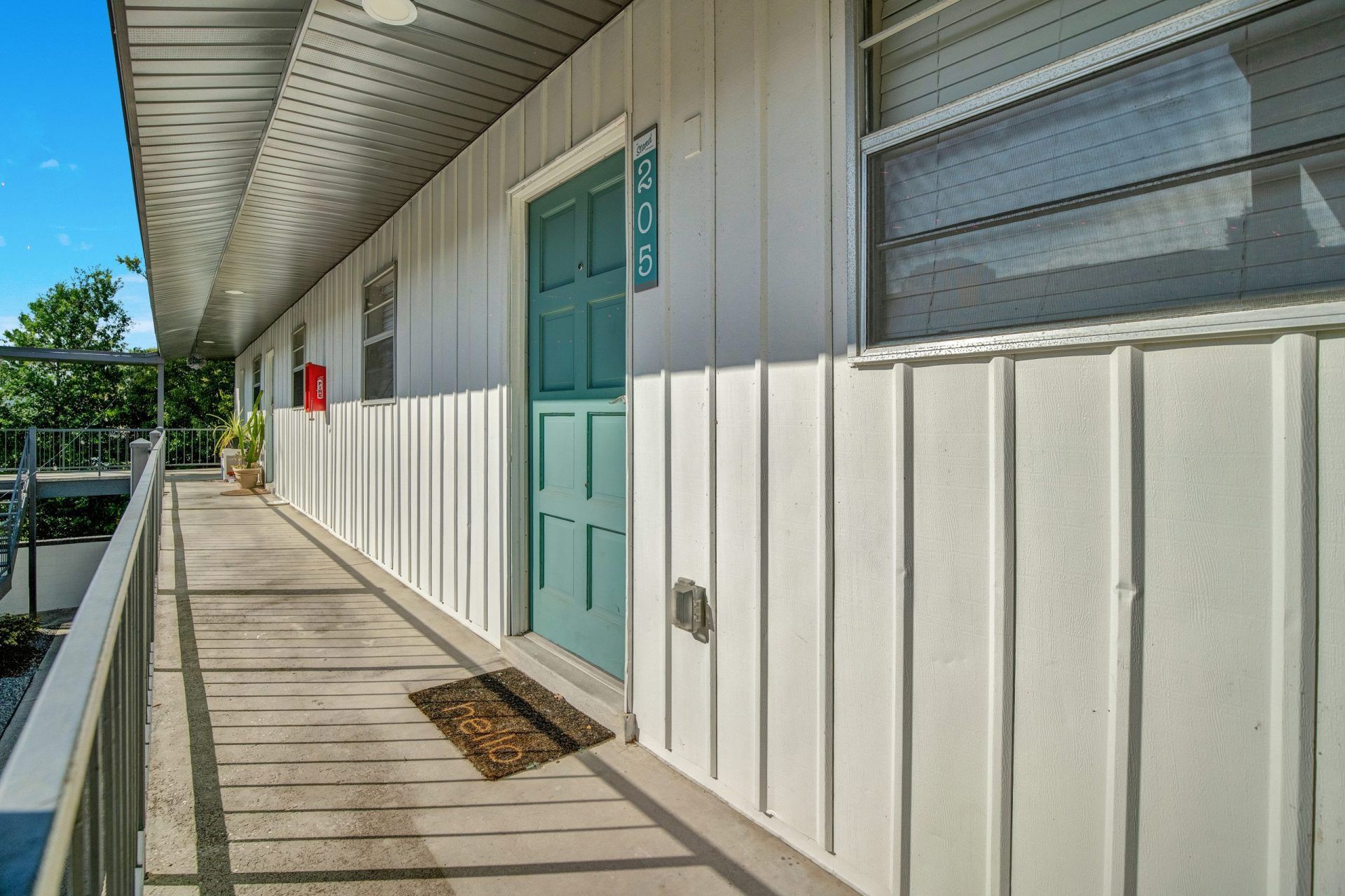 A long hallway leading to a green door in a building.
