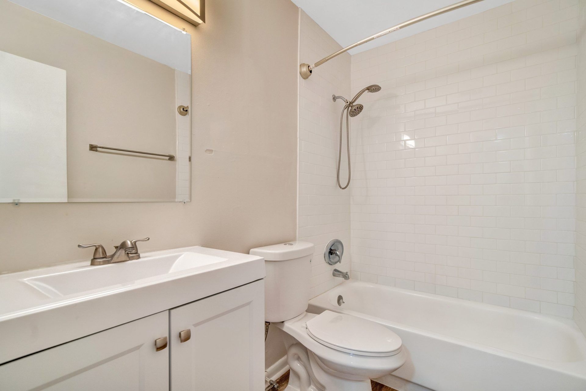A bathroom with a sink , toilet , bathtub and mirror.