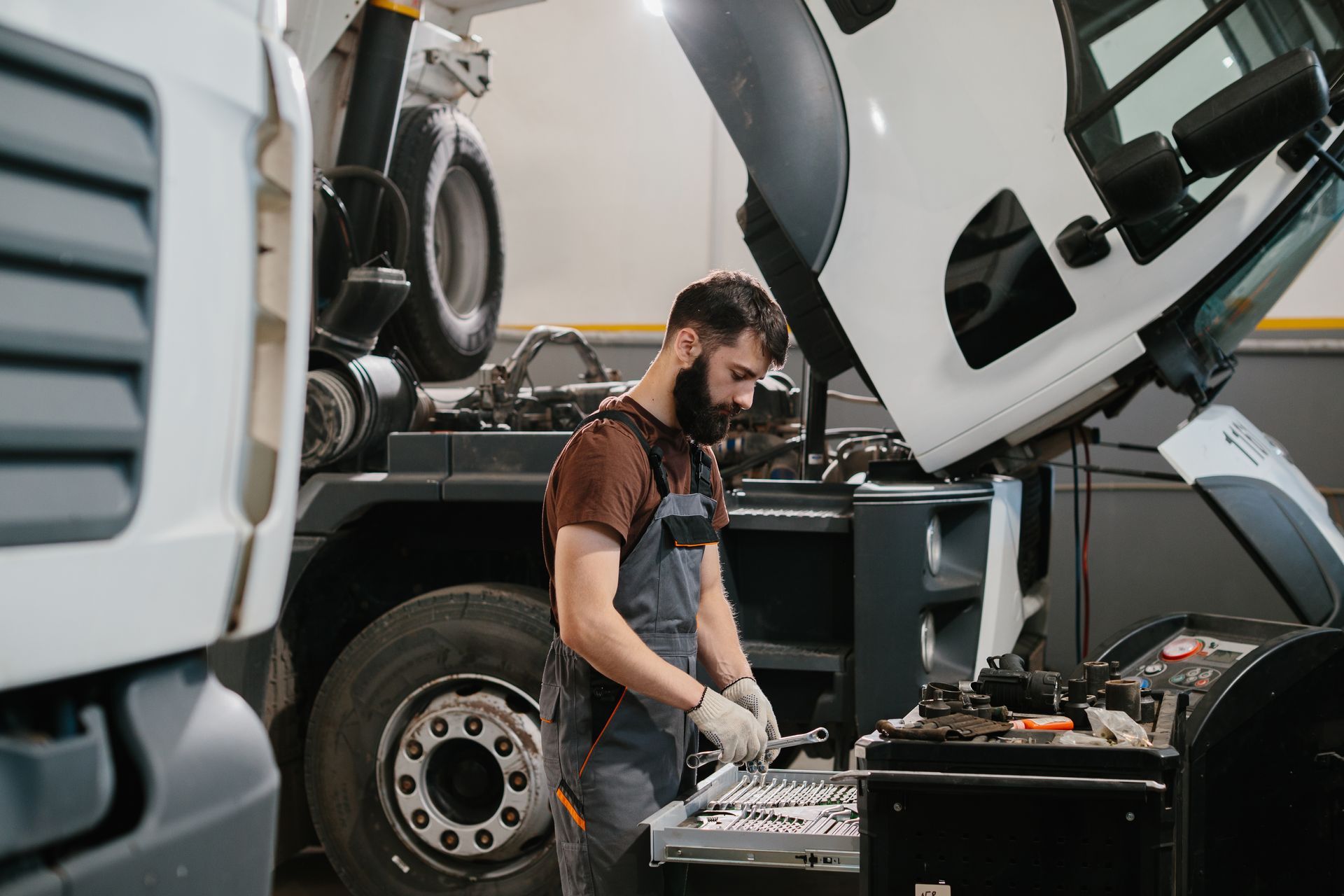 Professional auto mechanic choosing right wrench.